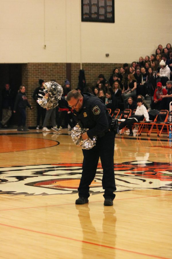 Waving his pom-pom, FHS Resource Officer Thomas Cole bows to the crowd. On Feb. 17, Cole performed with the FHS dance team during halftime of the boys varsity basketball game. 