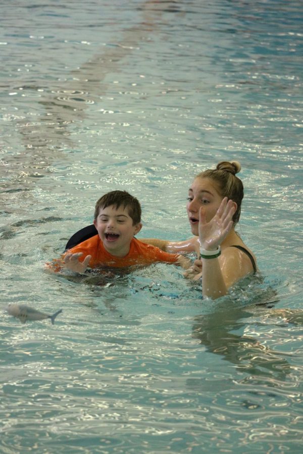 Senior Sophie Crane throws the toy for the World of Wonder student. On March 14th a group of FHS students swam with a group of preschoolers.