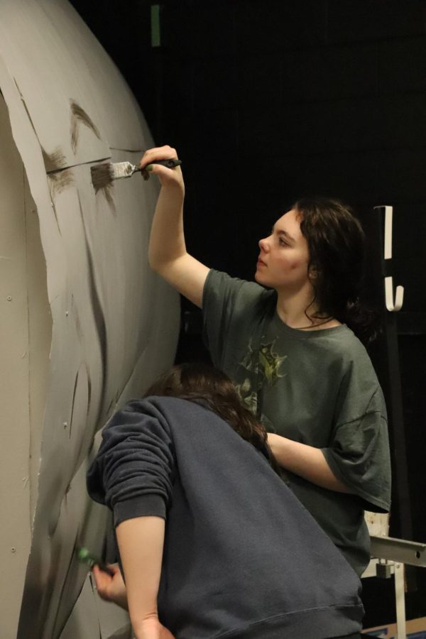 Reaching up, sophomore Isabella Butzine paints the plane. On March 8, the FHS theatre program prepared the set for their production of The Lord of the Flies. 