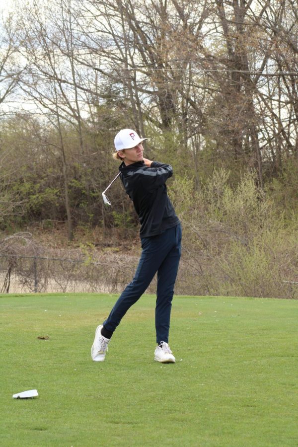 Looking for his ball, junior Carter Will finishes his swing. On April 26, the varsity golf team played Clio. 