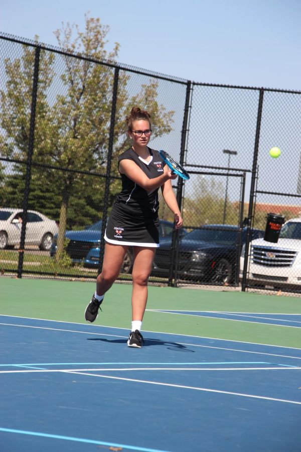 Swinging her racket, sophomore Ruby Wojtaszek hits the ball. On May 11. the JV Girls Tennis team competed against Powers Catholic and lost.