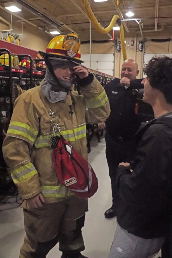 Laughing, seniors Roanan Stellberger and Ryan Stock dress in a fire fighter uniform. On May 3, Matt Sullivans Forensic Science took a field trip to the Fenton Fire Station.