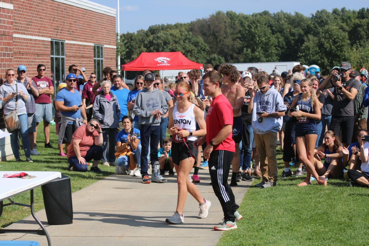 Accepting her medal, senior Nina Frost wins 1st place running a 19:56 in the varsity girls cross country race. On Sept. 23, Fenton took 3rd place at the 40th Linden Classic.