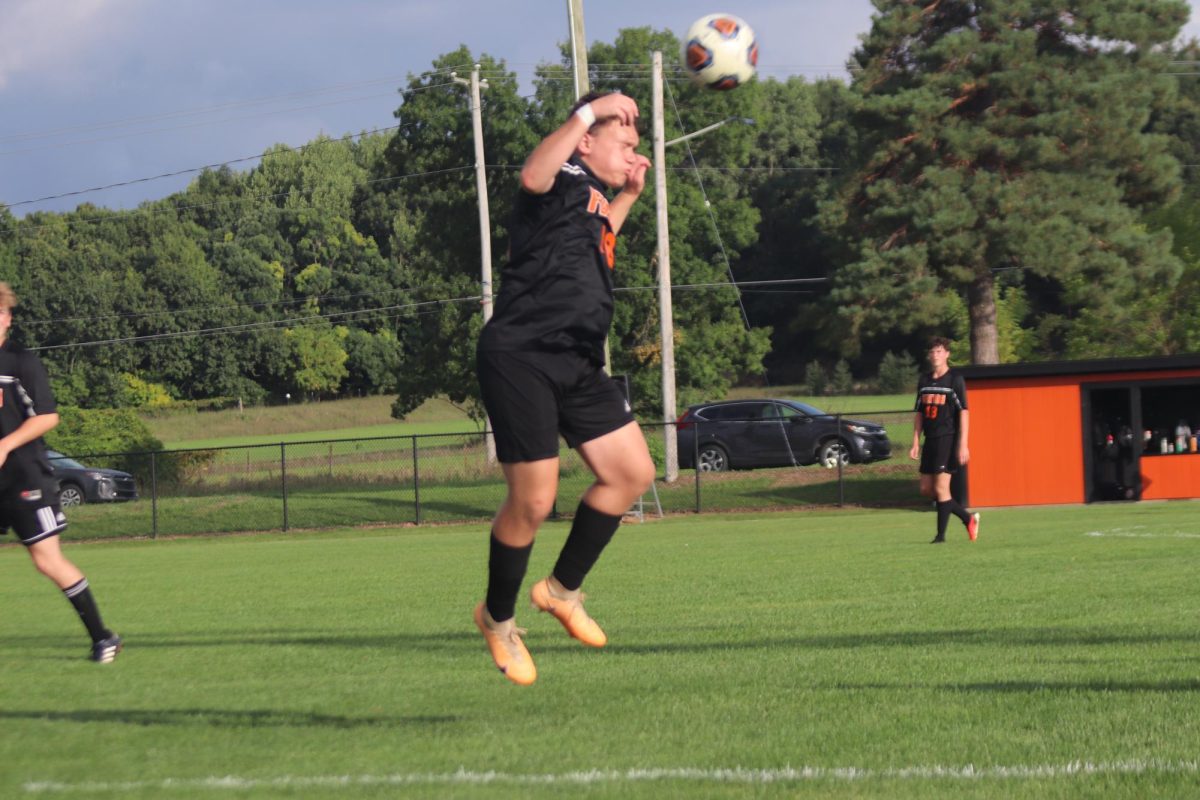 Heading the ball, Sophomore Riley Barnhill moved the ball up field. On Sept. 6, the Fenton Tigers competed against East Lansing and lost 0-6.