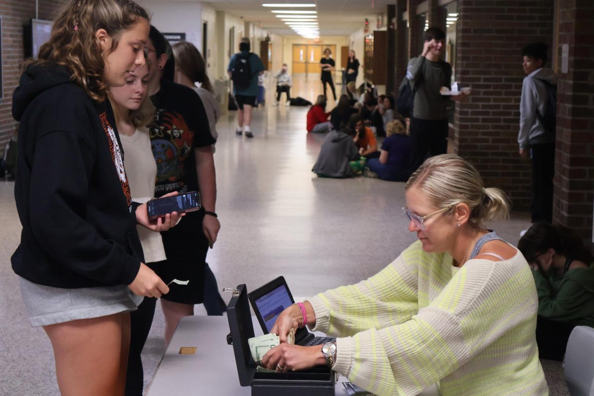 Preparing to buy a Homecoming Ticket, Sophomore Grace Perry pays $20 to attend homecoming.  On Sept. 27, Student Council sold tickets during lunch.