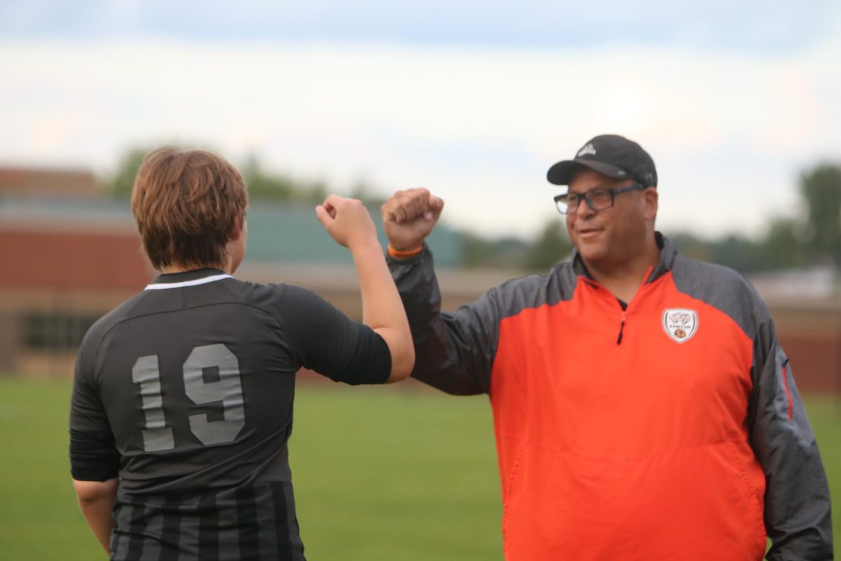 Junior Ian Elshols gets pumped up by his coach before heading on the feild. On sept. 18 the Fenton Tigers competed against Corruna and won 7-0