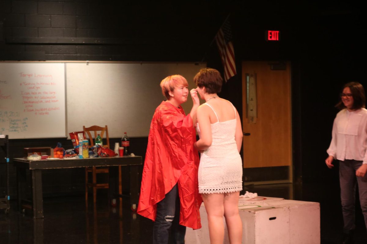 Applying makeup, freshman, Elliot Green, Mark Allemon and Wendy Thibodeau recreate Katy Perrys Hot N Cold. On Sept. 8, Theatre teacher Lori Thompsons Advanced drama third hour preformed 2000s themed music videos. 