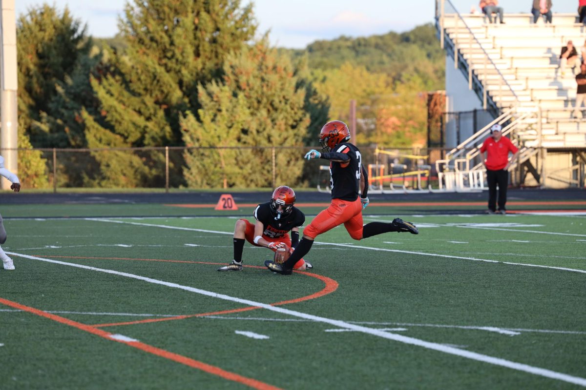 Kicking the ball, sophomore Cruz Gomez attempts to score a field goal. On Sept. 14, the Fenton JV football team competed against Holly and won 49-0.