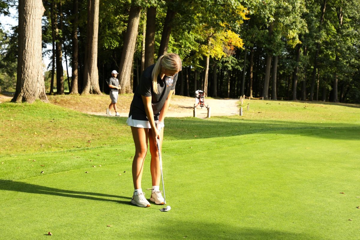 Looking at her line, Junior Maddie Knight prepares to putt. On Sept. 21, the JV golf team played against the Flushing Raiders and won.