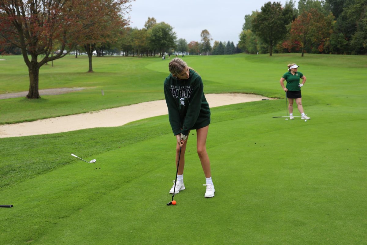 Looking at her line, junior Olivia Kowalski prepares for her next shot. On Sept. 28, the girls JV golf team played against Howell at Fenton Farms and won.