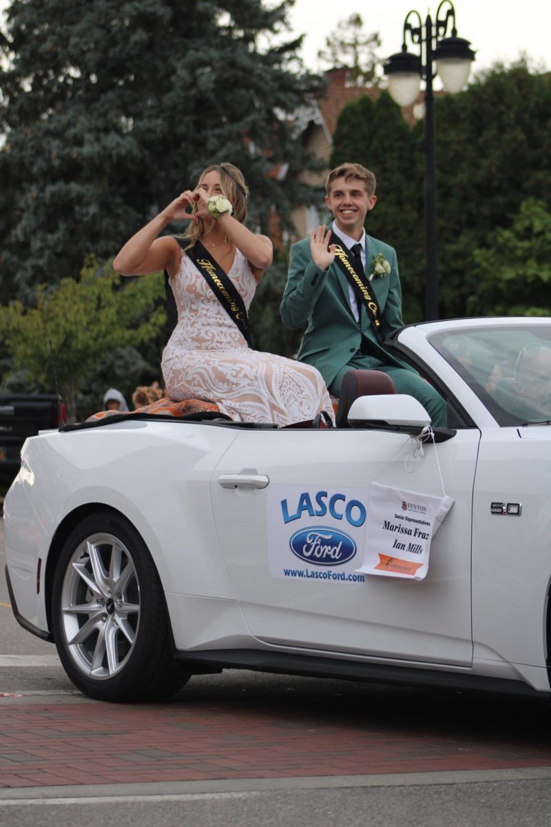 Smiling%2C+seniors+Marissa+Frazier+and+Ian+Mills+represent+their+class+in+the+homecoming+parade.+On+Oct.+6%2C+the+2023+homecoming+court+representatives+rode+in+the+parade.