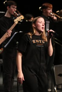 Singing, senior Macy Wright preforms for the crowd. On Oct. 26, the FHS band held a concert at the Fenton high auditorium. 