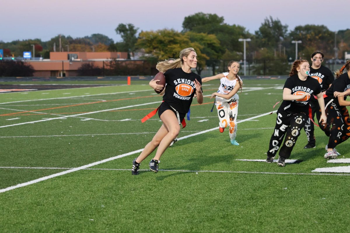 Running the ball, senior Sophie Smith gains more yards for her team. On Oct. 2, The FHS senior and junior girls played each other in powderpuff were the seniors won.