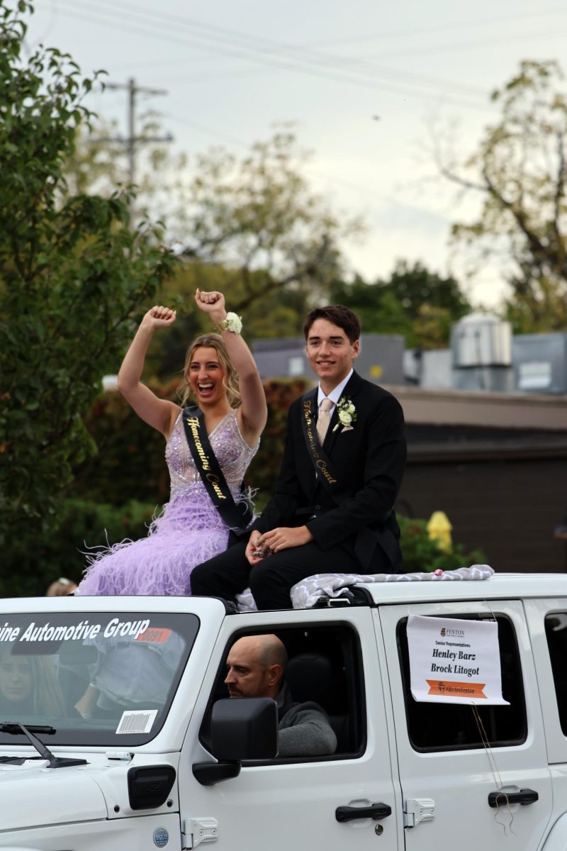 Riding in the car, seniors Henley Barz and Brock Litogot represent their senior class. On Oct. 6, Fenton High School holds the annual homecoming parade.