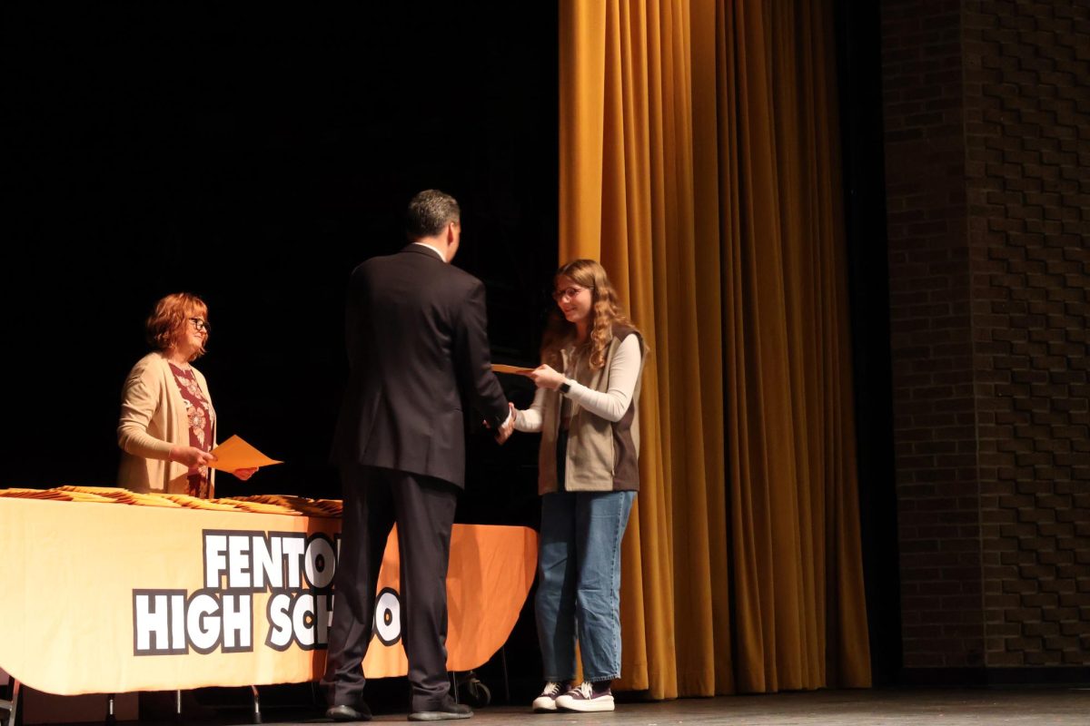 Congratulating junior Addison Browne, Principle Bakker hands out her academic letter. On Oct. 17 fenton held a academic letter assembly for 210 students. 
