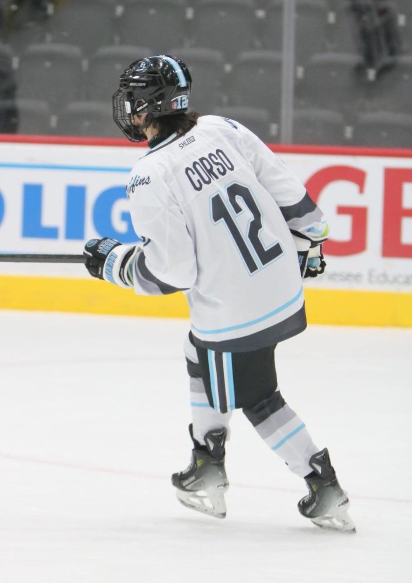 Skating, junior Dom Corso goes down the ice while playing defense. On Nov. 17, the varsity hockey team had their home opener vs Capital City at Dort Federal Financial Center.