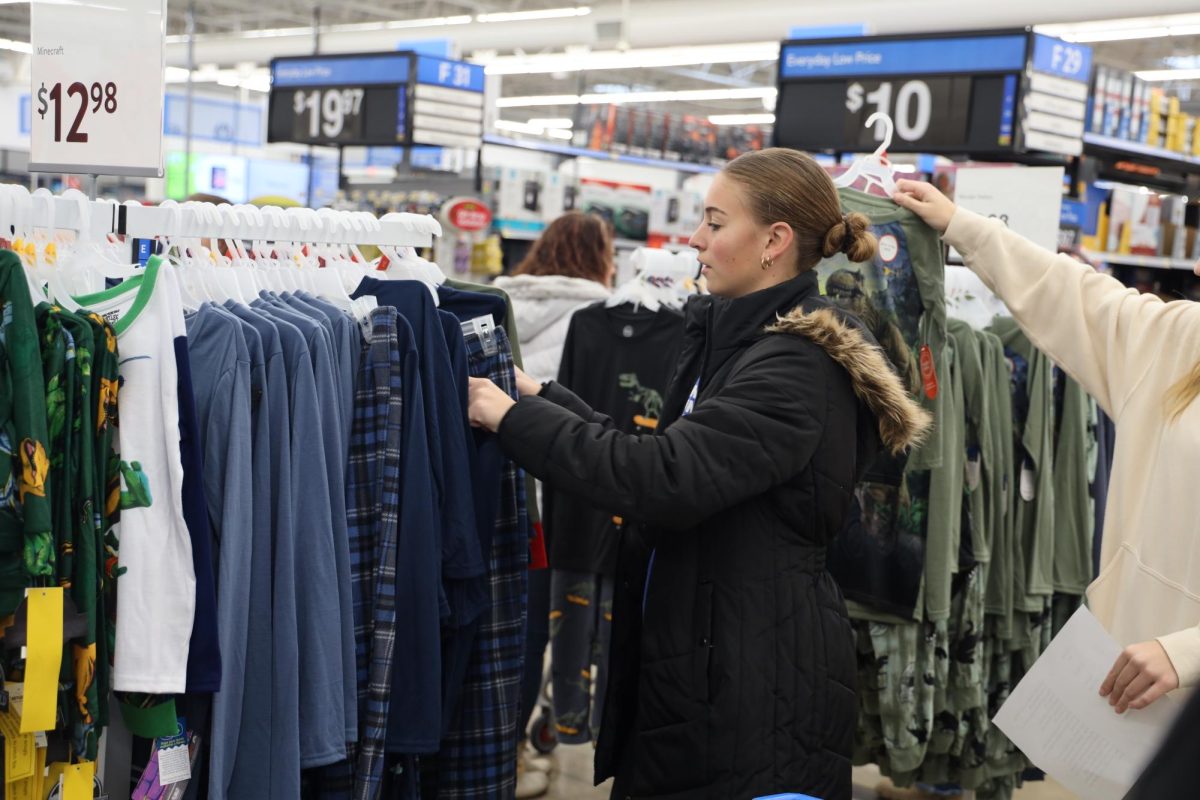 Picking out pajamas, junior Taryn Craven shops for someone on the wishing tree. On Dec. 2, the girls JV and varsity basketball teams shopped at walmart for the wishing tree. 