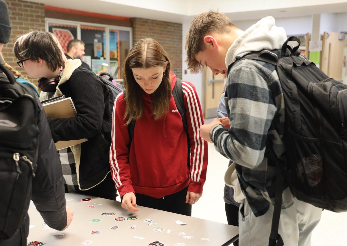 Picking out a sticker, freshman Madi Rohde participates in Positivity Thursday. On Dec. 7, students had the opportunity to get stickers before school.