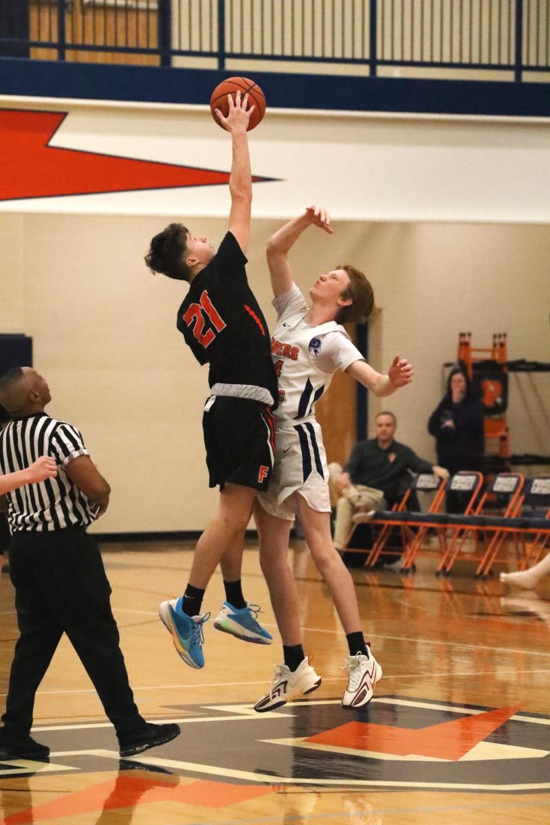 Jumping for the ball, freshman Grant Hunault does jump ball to start the game. On Dec. 9, the boy's freshman basketball team went up against Powers Catholic High losing 52-53 after going into over time. 