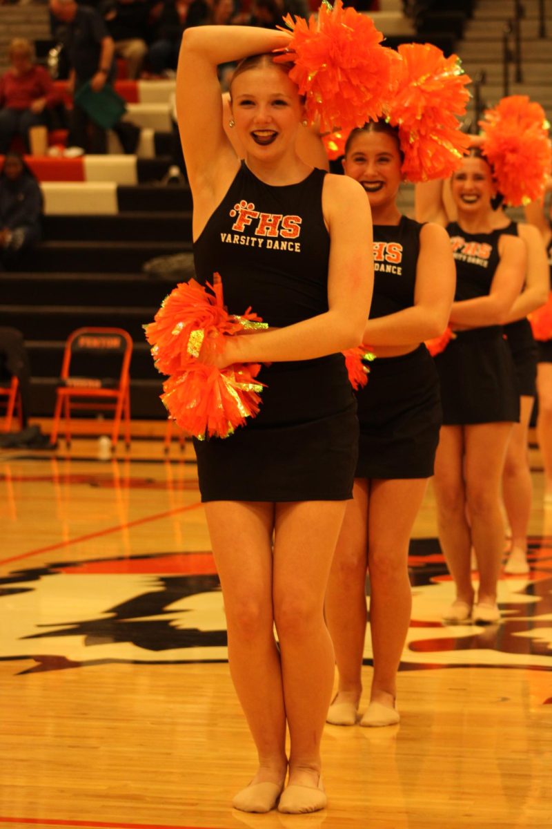 Holding her pose, sophomore Kyla Moore dances with her team. On Dec. 8, the varsity dance team performs during halftime of the boys varsity basketball game.