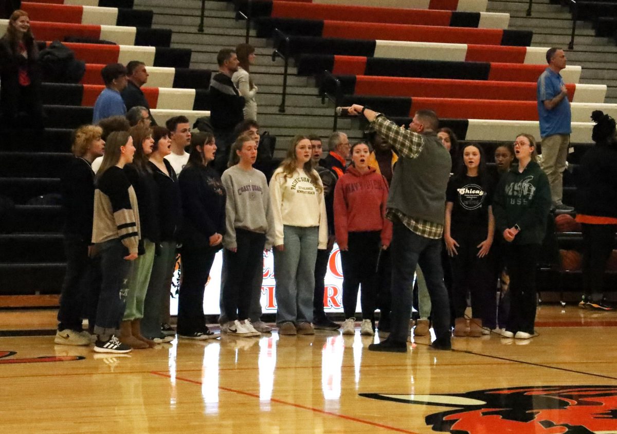 Focused, the Fenton ambassadors sing the National Anthem. On Jan. 22, the ambassadors sang the National Anthem before the girls varsity basketball game. 