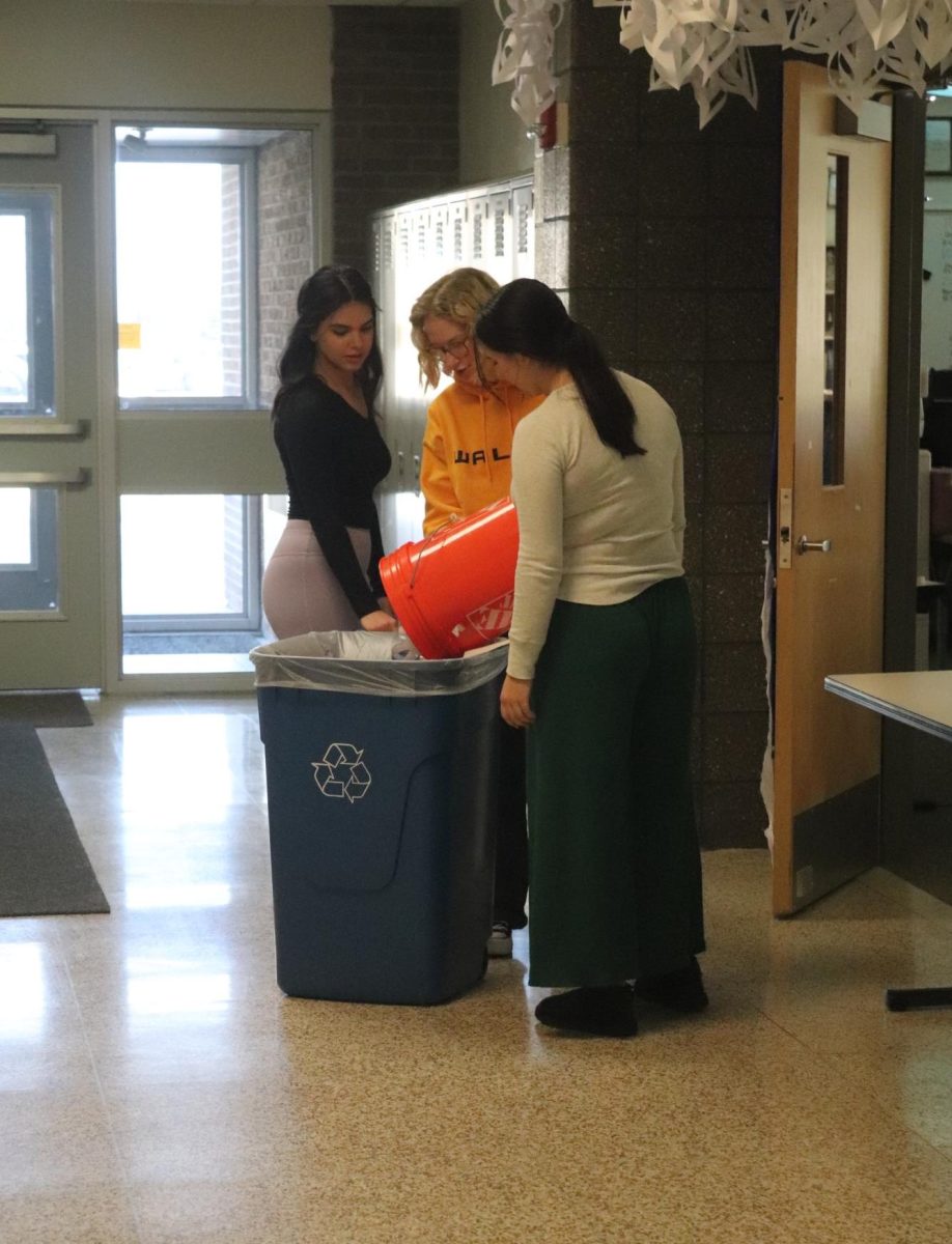 Holding the bucket, members of the Eco Club recycle cans. On Jan. 4, the E.C.O Club collected cans during SRT.
