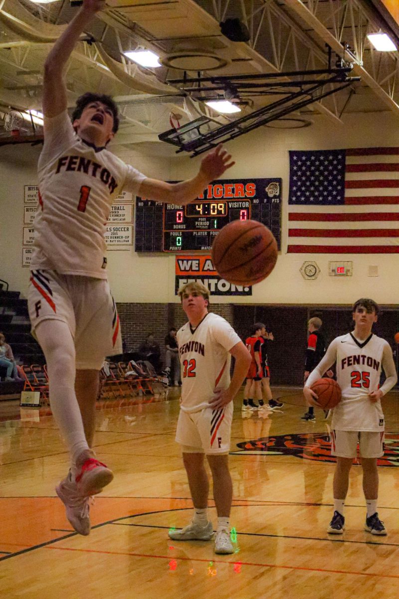 Dunking, Landon Becker warms up for his game. On January 21, Fenton's JV boys basketball team played against St.John. 