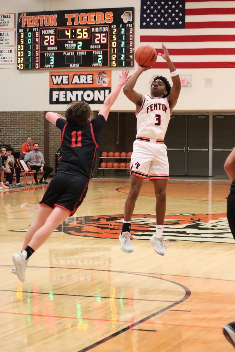 Shooting the ball, Senior Ja Hion Bond is trying to make a three. On Jan. 19, Fenton boys Varsity beat Linden 81-66.