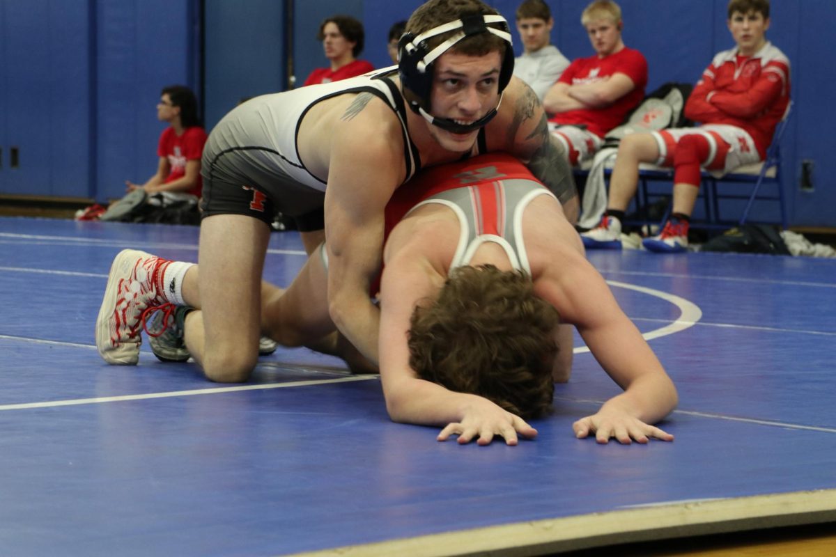 Wrestling, Junior Kaleb Digiacomo attempts to pin his opponent. On Jan. 3, the boys varsity Tigers goes up against Holly and won 55 -18 