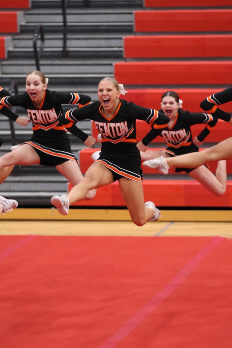 Jumping, Junior Lydia Klemish and teammates compete in round one. On Jan. 26, the Fenton Cheer team takes 4th place at the second Flint Metro League Competition.