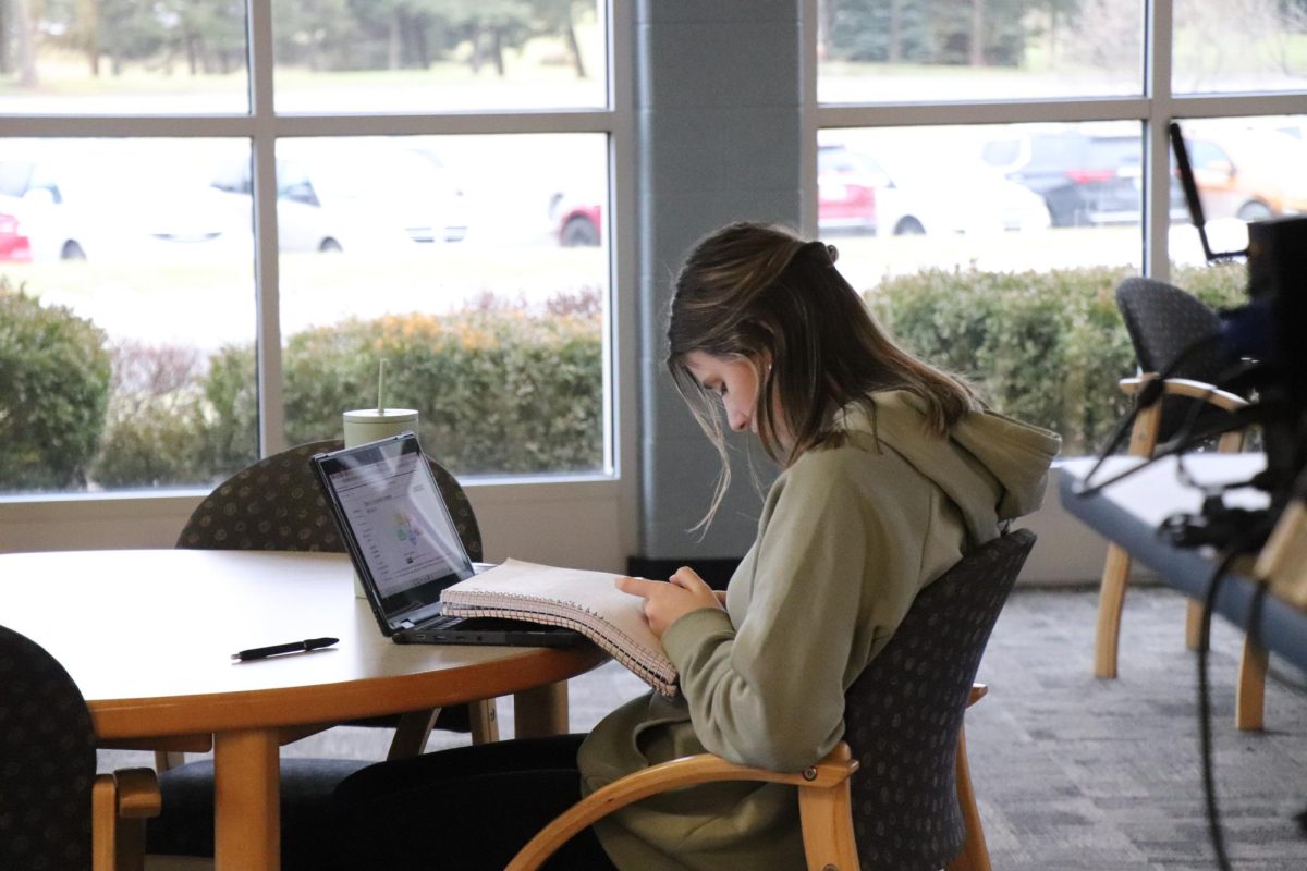 Doing homework, junior Abigail Dekracker studies. On Jan. 29, online classes took place in the media center. 