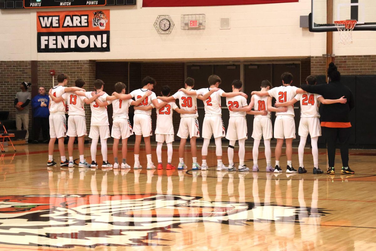 Standing, the boys freshman basketball team listens to the national anthem. On Jan. 11, the tigers went up against Kearsley High and won 76-24. 