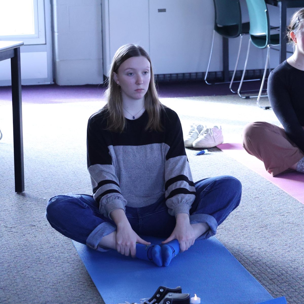 Stretching, senior Macy Wright gets in the butterfly position. On Feb. 6, she joins yoga with sunny during srt.