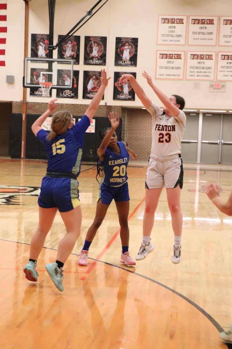 Jumping in the air, Senior Allie Michewicz tries to shoot a three. On Feb. 9, the varsity basketball team played Kearsley and lost. 