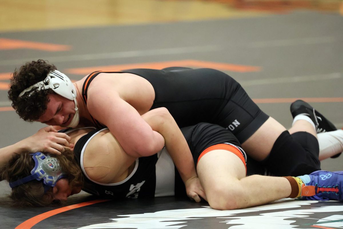 Wrestling, junior Christopher Dobek attempts to roll his opponent over for a pin. On Feb. 8, the wrestling team participated in districts and placed 3rd.
