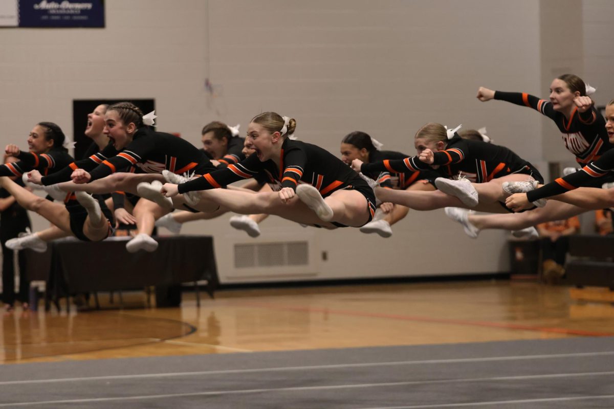 Jumping, the Fenton Cheer Team competes in round one of the cheer comp. On Feb. 9, the Fenton Cheer Team took 3rd place in the Flint Metro League.