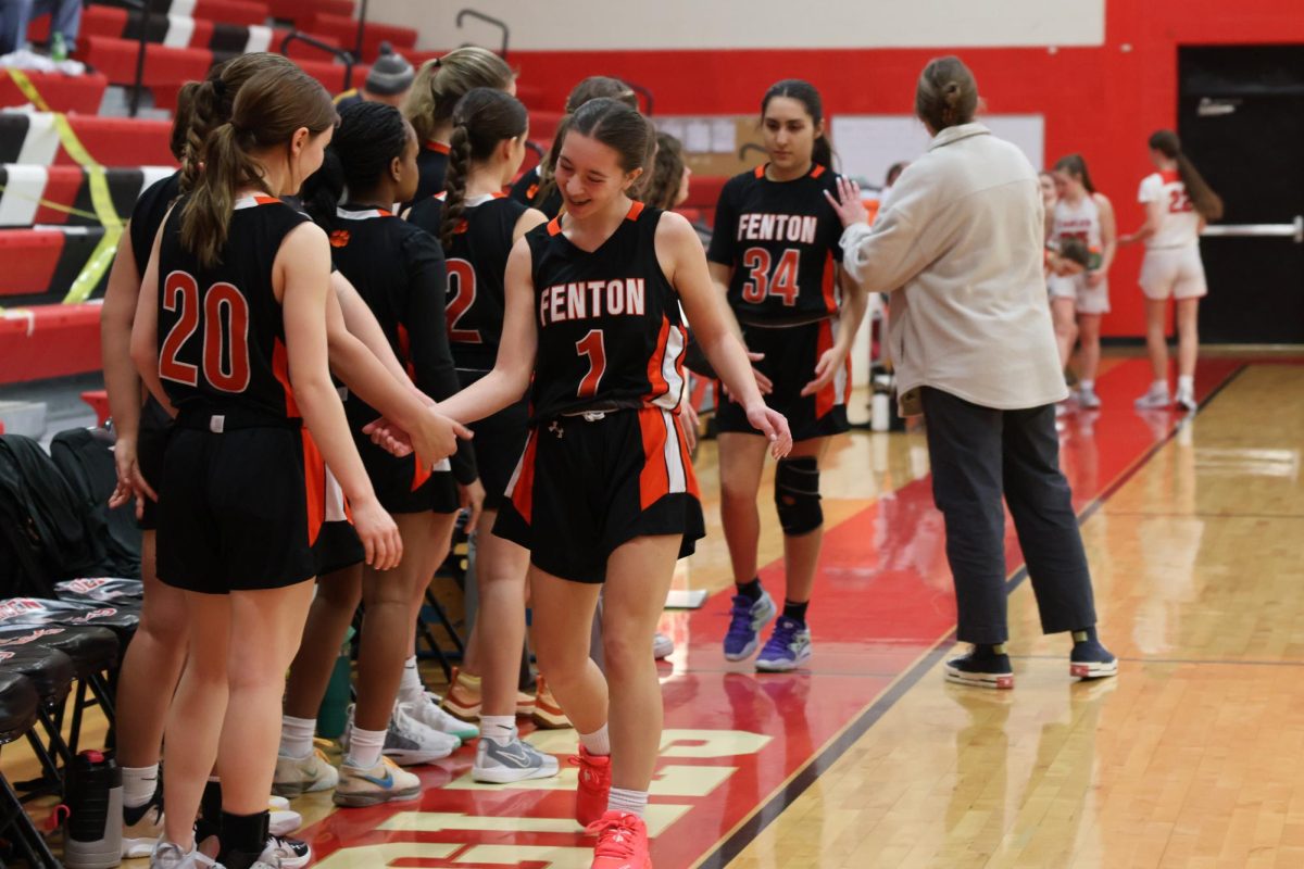 Getting cheered on by their teammates, sophomore Maya Richmond and freshman Anna Koscielniak walk back to the bench. On Feb. 16, the JV girls basketball team played the Linden Eagles and lost 45-26.