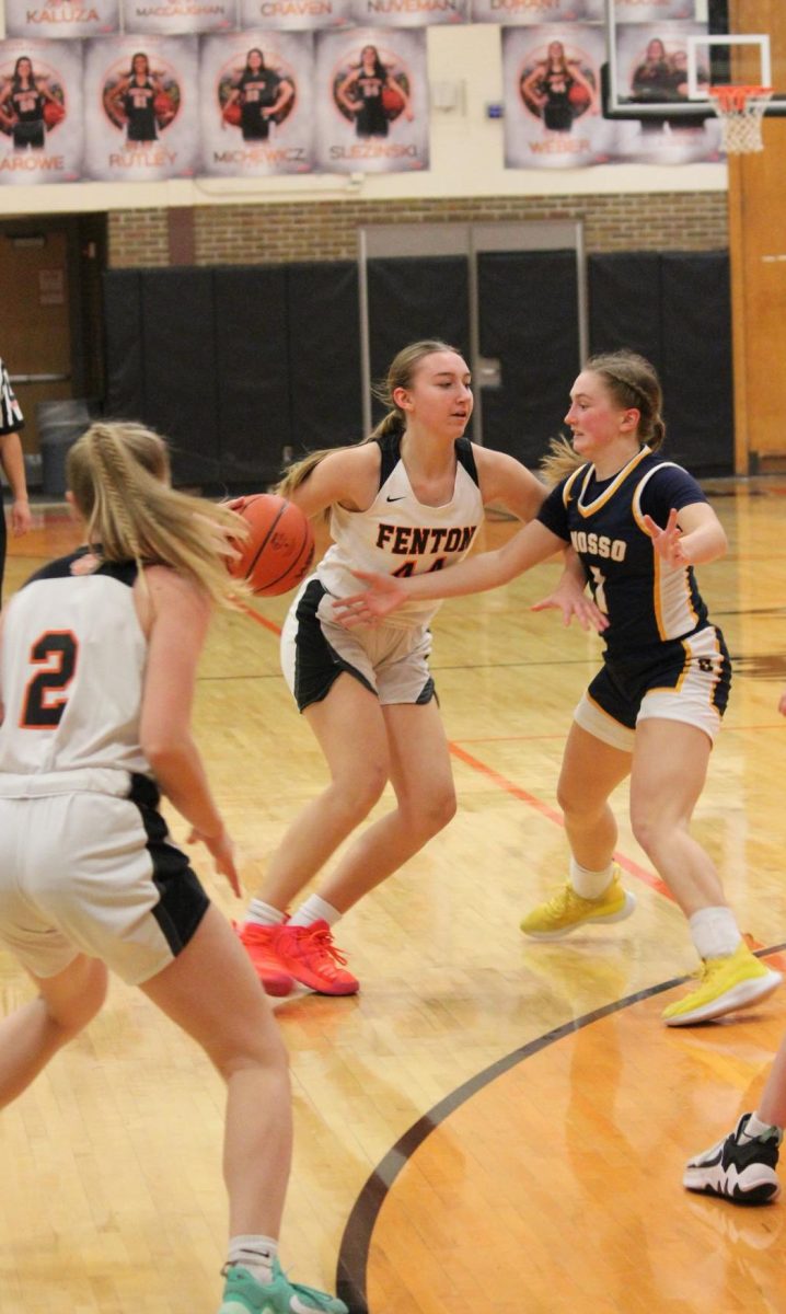 Dribbling the ball, Freshman Lucy Weber defends the ball. On Feb. 20, the varsity basketball team played Owosso and lost. 
