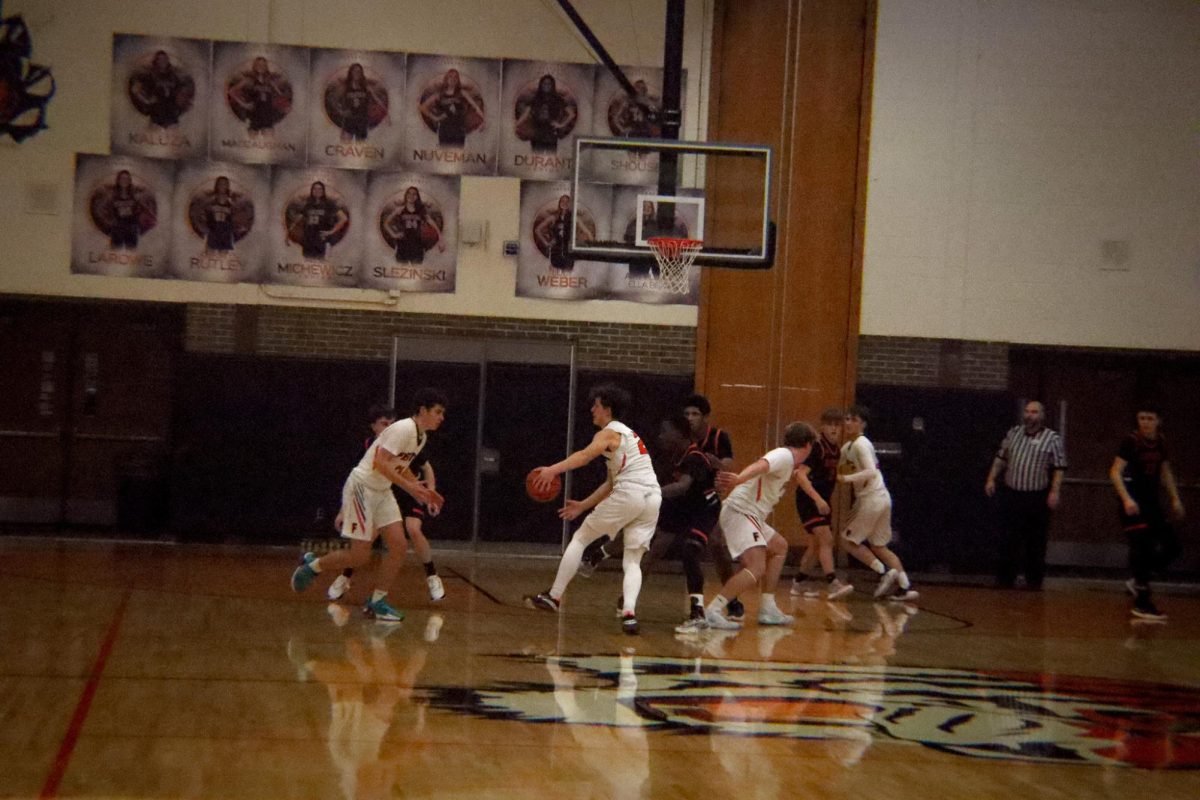 Dribbling, the JV boys basketball team plays offense. On January 25, Fenton played against the Flushing raiders. 