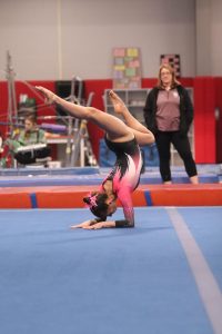 Holding an elbow stand, senior Jillian Shanahan competes at the Linden multi-purpose building with her high school team. On Feb. 21, LFLF won against Cass City. 