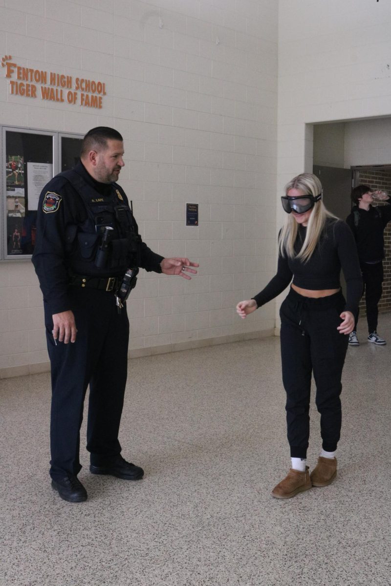 Balancing, junior Maddie Knight takes a sobriety test while wearing drunk goggles. On Feb. 2, a Fenton police officer visited FHS to go through basic tests with Mr. Sullivans classes.