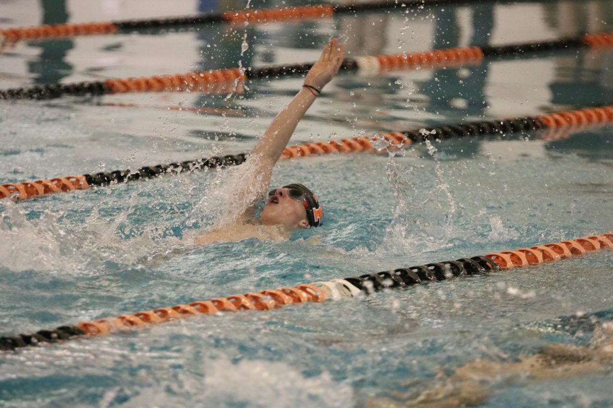 Swimming, freshman Lucas Raby participates in a competition. On Feb. 23, the FHS boys swim team took part in the Flint Metro League.