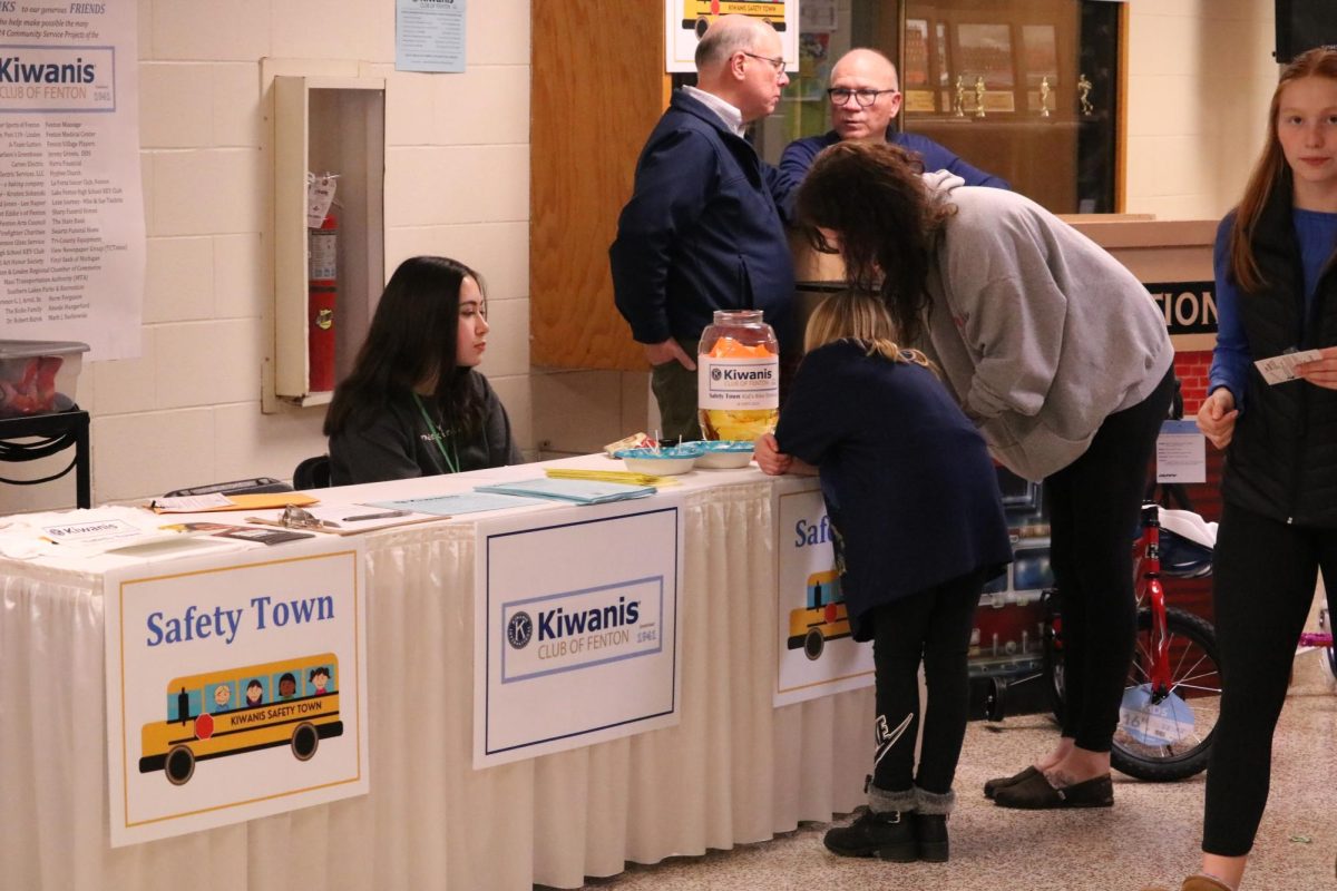 Helping a citizen, freshman Janessa Bemman tells a community member about Safety Town. On March 3, the Fenton High School hosts their yearly EXPO event.