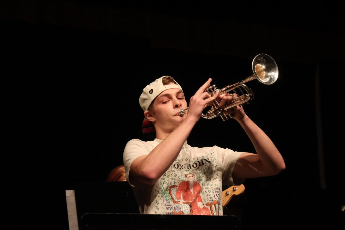 Practicing his solo, senior Daniel Martens performs in the auditorium in front of a group of students. On Mar. 19, the FHS Jazz Band practiced in the auditorium before they went to states.