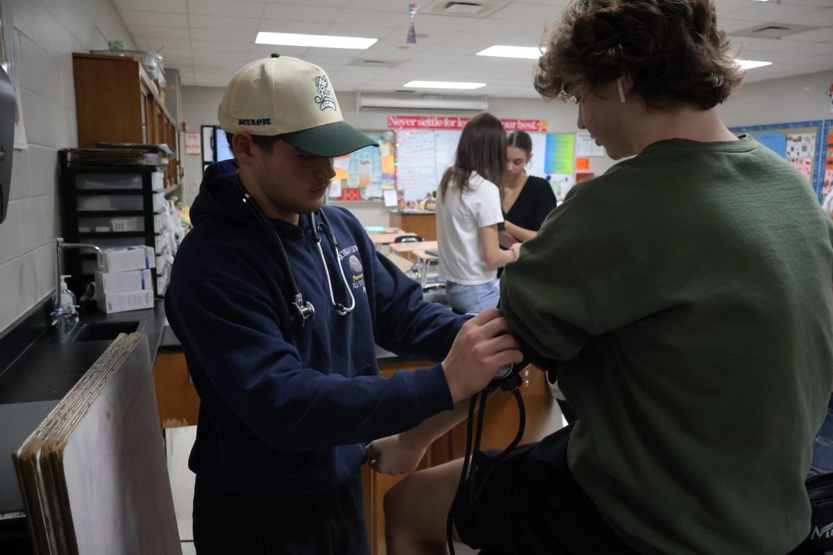 Preparing, Senior Lucas Nye checks his classmates blood pressure. On March 13, Mrs. thomass class does a blood pressure lab.