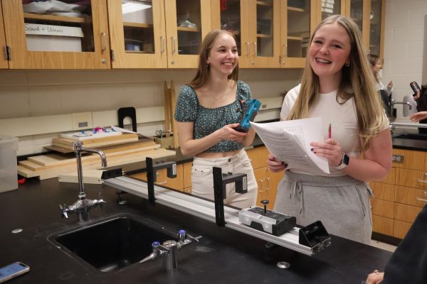 Laughing, sophomores Cassie Harris and Ridley Hedrick finish a lab. On March 14, science teacher Jason Kasak held a calculating  momentum lab. 
