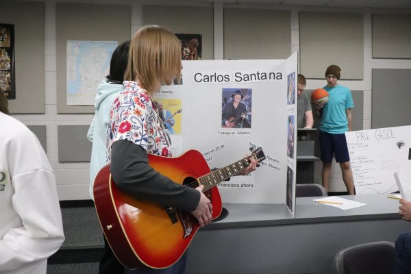 Holding a guitar, Sophomore Caleb Wolner plays a song for students. On Mar. 20, Spanish 2 dressed up for a wax museum.  