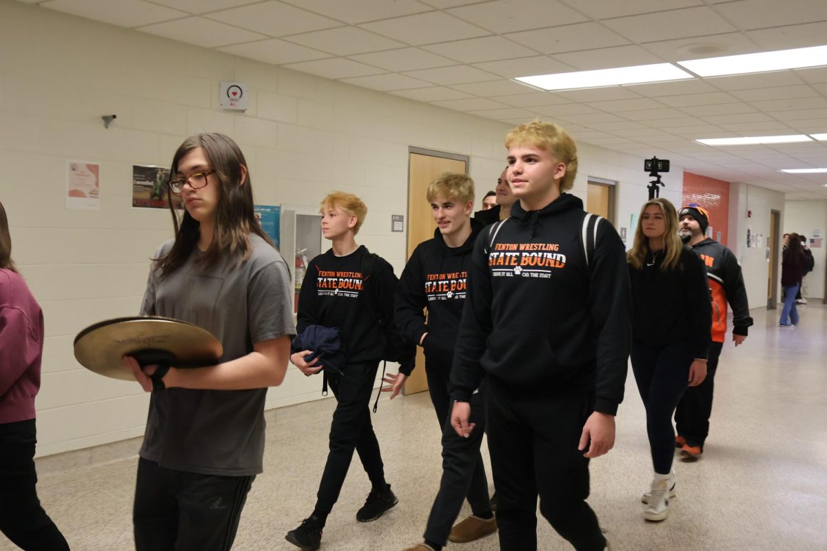 Getting lead out by the Fenton drumline, sophomore Aiden Velzy and seniors Ben Triola and Carson Krzeszak head off to states. On Feb. 29, staff and students cheered on the wrestlers that qualified for states.