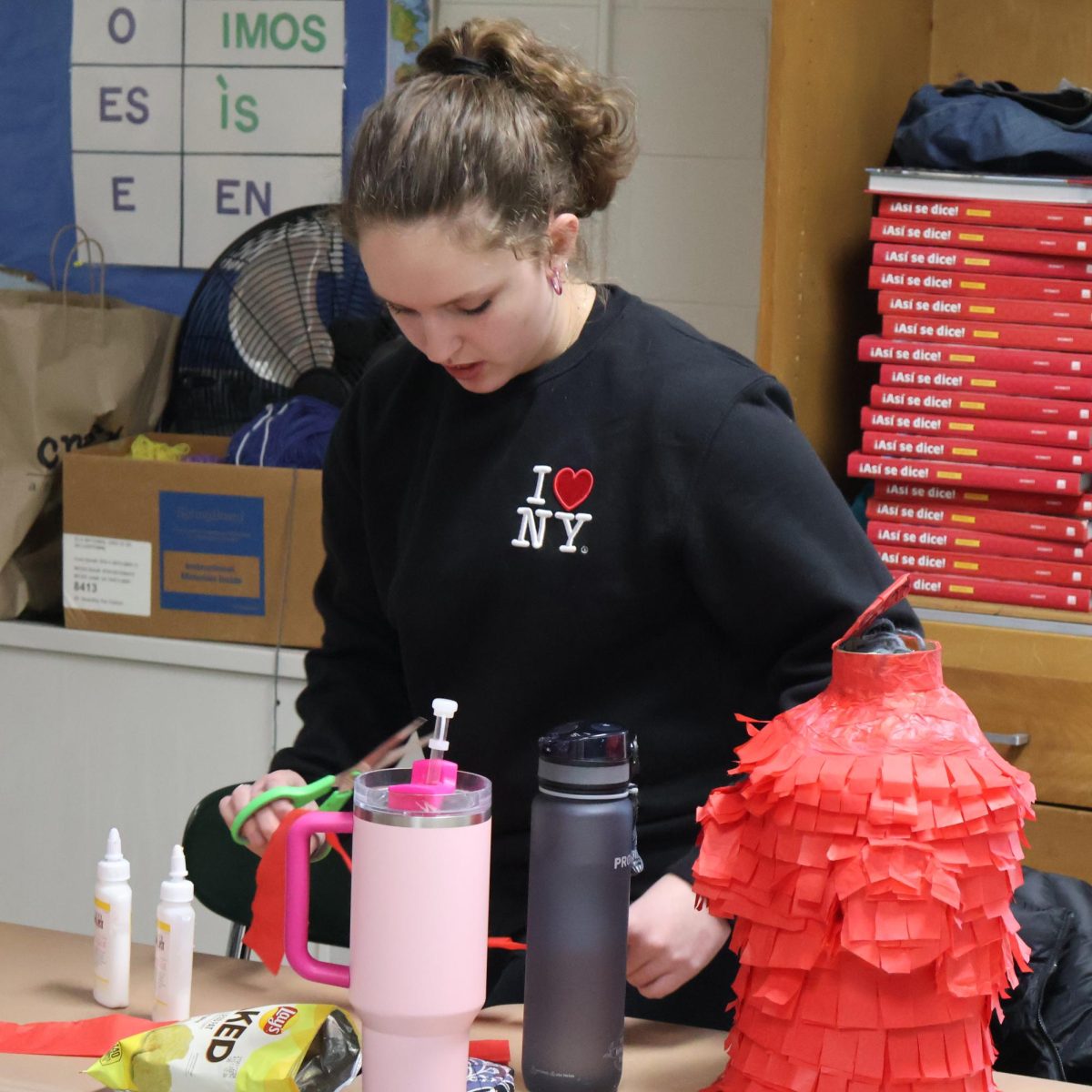 Cutting paper, sophomore Abigail Golen makes a pinata. On March 21, teacher Hillary Fischer had her students make pinatas in spanish class.