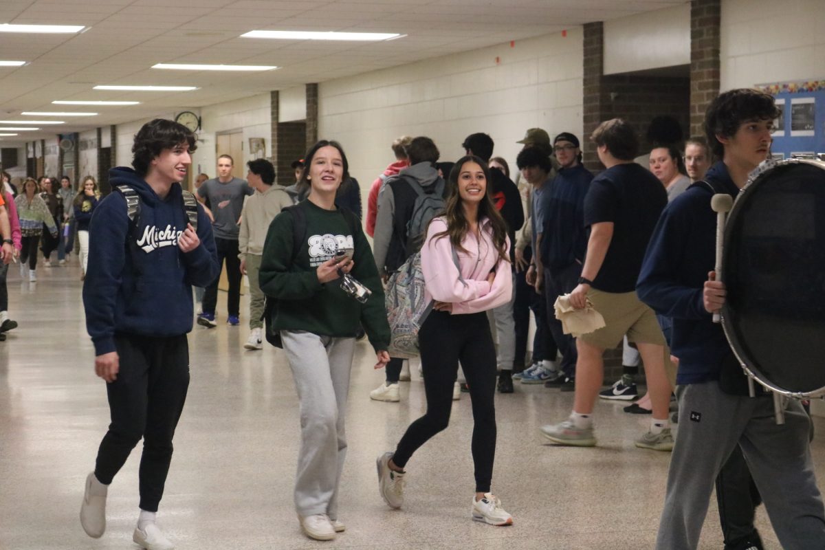 Walking through the halls, Jillian Shanahan, Molly Dixon and Owen Cox get clapped out. On March 7, the band lead the students through the halls as they left for states.